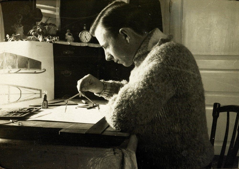 A draughtsman working on furniture plans at a drawing desk